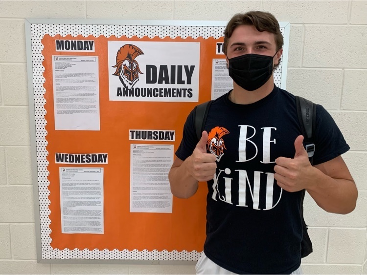 student standing in front of the daily announcement bulletin board